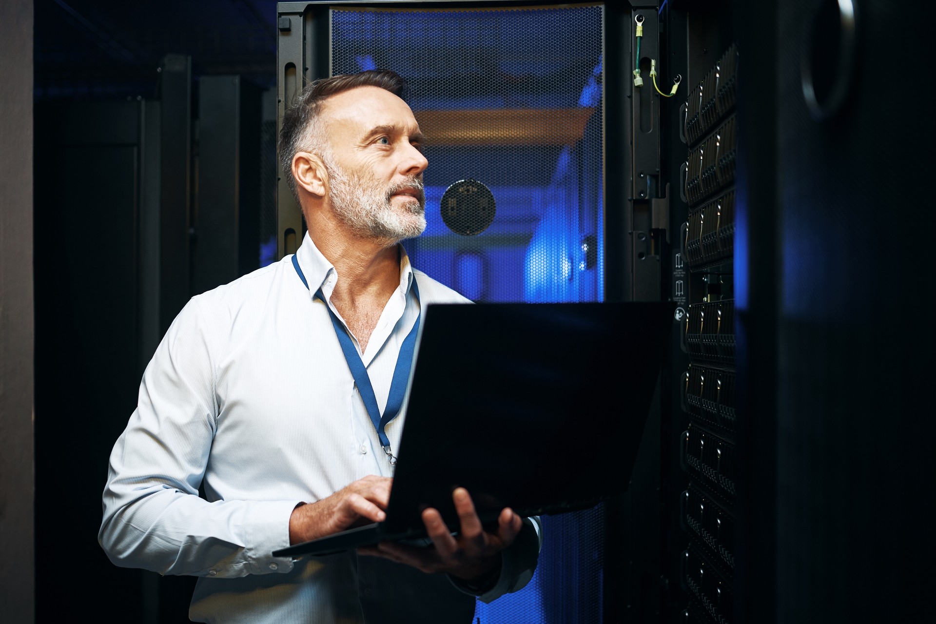 Shot of a mature man using a laptop while working in a server room